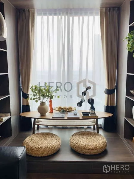 Condominium for rent - Extended Zen Space balcony with oval table, shelving and two woven stools by the window.