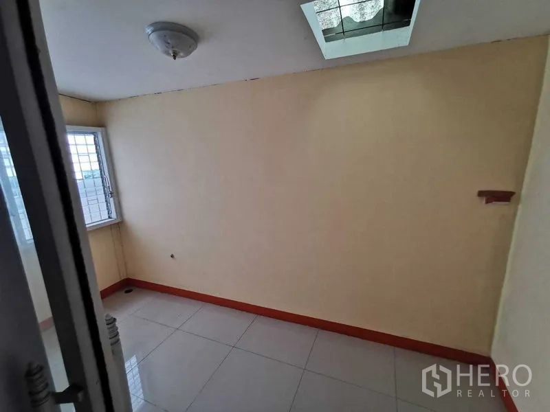 Shophouse for rent in Suan Luang, Bangkok - Compact room with tiled floor, corner window and ceiling skylight.
