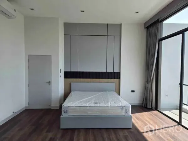 独立式住宅 出租在Bang Phli, Samut Prakan - 宽敞卧室，背景墙、双人床，落地推拉门通阳台。