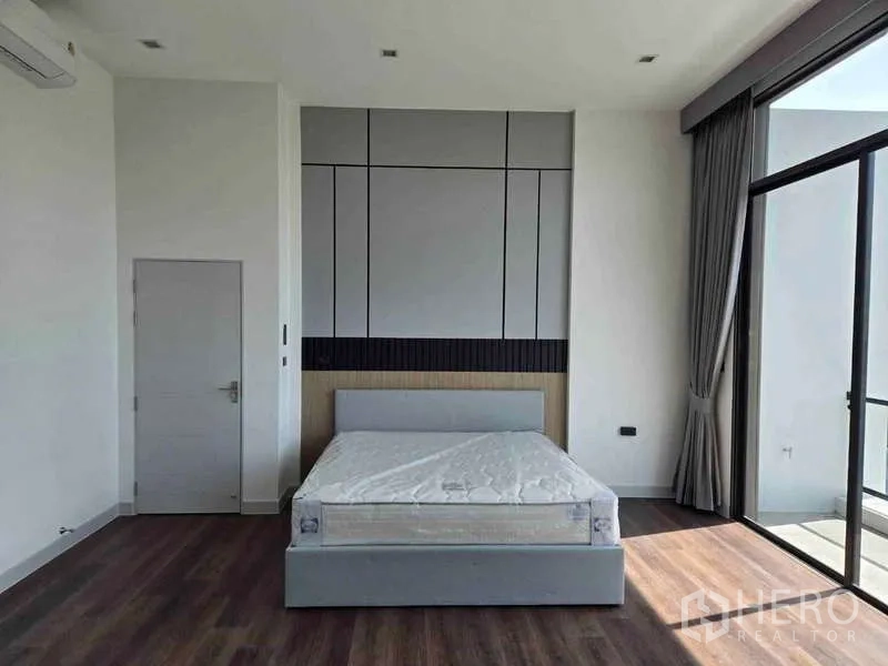 独立式住宅 出租在Bang Phli, Samut Prakan - 宽敞卧室，背景墙、双人床，落地推拉门通阳台。