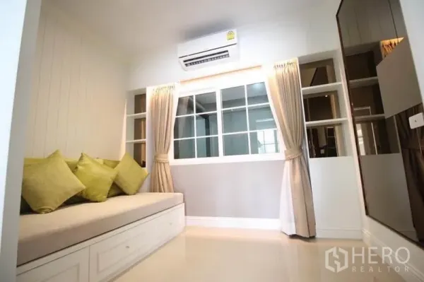 Detached House for rent or sale in Lat Phrao, Bangkok - Cozy multipurpose room with daybed, shelving and curtained window.