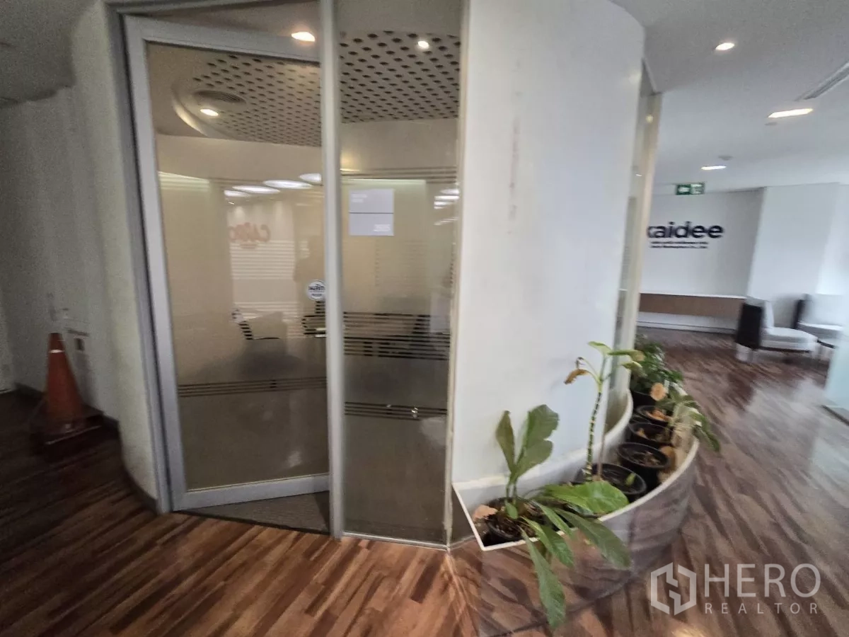 Office Space for rent in Watthana, Bangkok - Curved planter with indoor greenery beside glass office entrance.