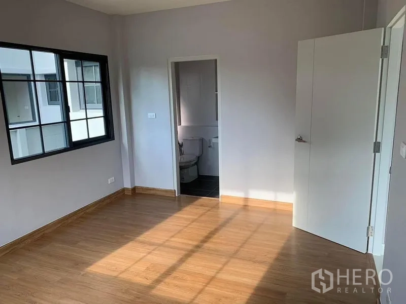 Detached House for rent or sale in Bang Phli, Samut Prakan - Bedroom with wood flooring, large window and en-suite bathroom