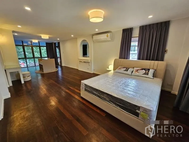 Detached House for rent - Expansive master bedroom with wood floors, central desk island, and soft lighting.