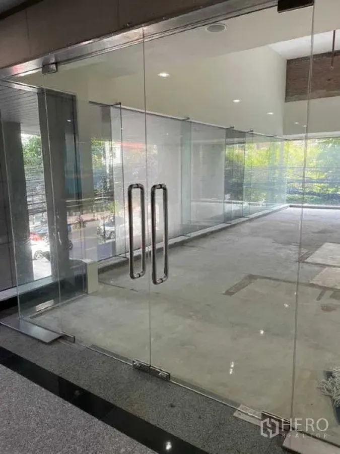 Office Space for rent in Watthana, Bangkok - Clear glass double doors opening to an unfurnished office space with street outlook.