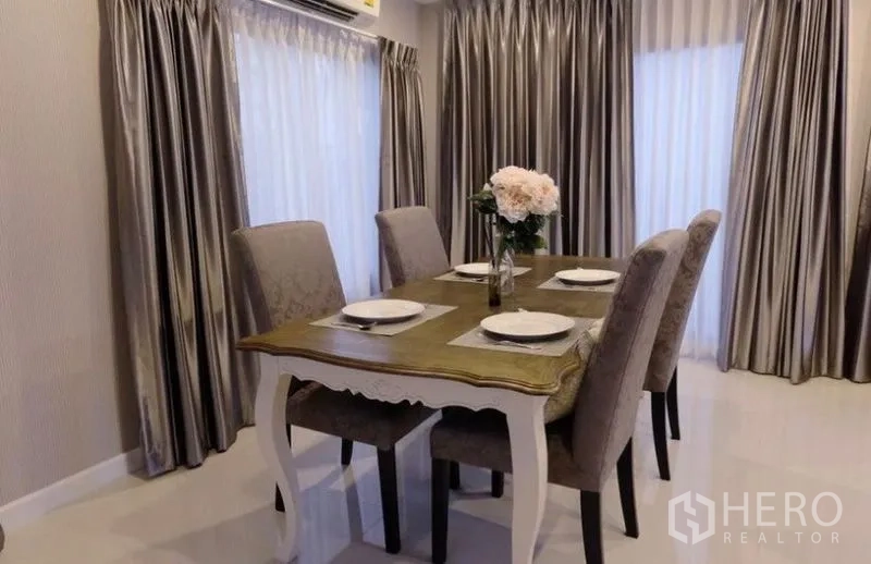 Detached House for rent in Suan Luang, Bangkok - Cozy dining room with four-seat table, upholstered chairs, and floor-to-ceiling curtains.