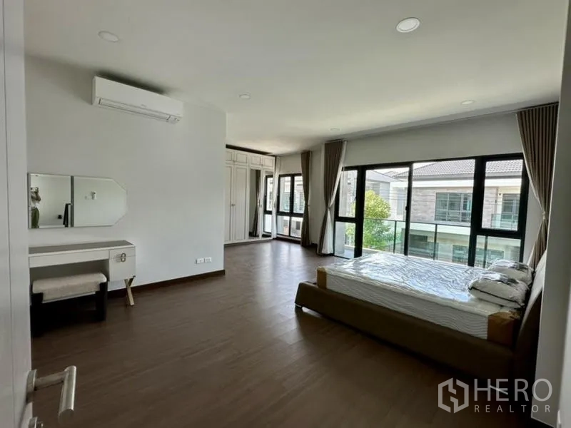 Detached House for rent in Bang Phli, Samut Prakan - Spacious master bedroom with floor-to-ceiling windows, wardrobe, and vanity table.