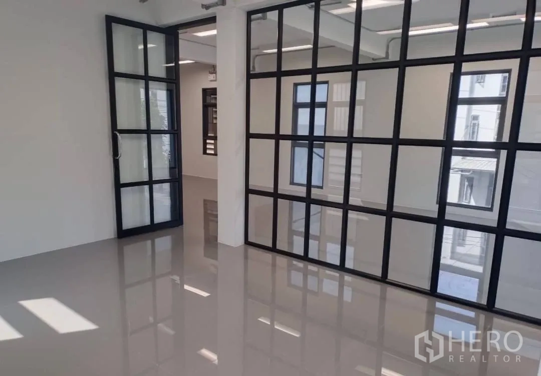 Factory for sale in Lam Luk Ka, Pathum Thani - Office zone with black-framed glass partition doors and glossy floor.