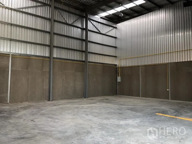 Factory for rent in Khlong Luang, Pathum Thani - Empty factory corner with electrical conduits on concrete panel walls.