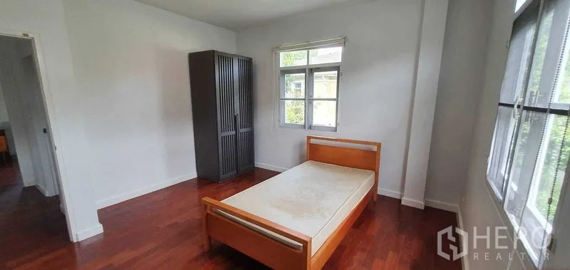 Detached House for rent in Prawet, Bangkok - Secondary bedroom with single bed, wardrobe and wide windows for natural light.