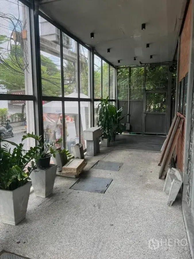 零售空间 出租在Watthana, Bangkok - 带玻璃立面的遮蔽走廊与绿植，临街店铺入口