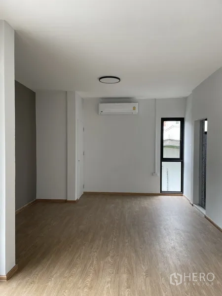Home Office for rent in Khlong Toei, Bangkok - Bright office room with wood-look flooring, air conditioner, and tall window