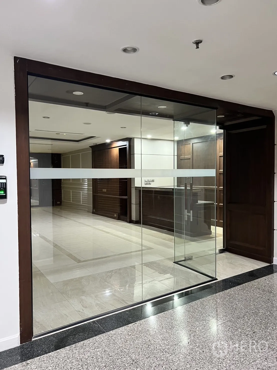 Office Space for rent in Watthana, Bangkok - Glass-walled office entrance with wood trim and marble floors.