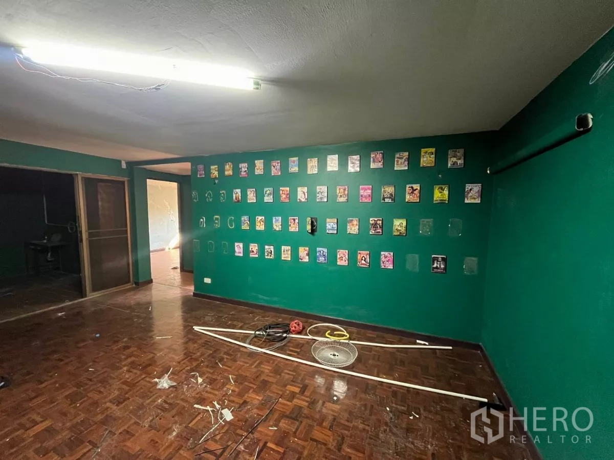店屋 出租在Watthana, Bangkok - 宽敞房间，绿色墙面、拼花木地板，墙上装饰画与推拉门相连。