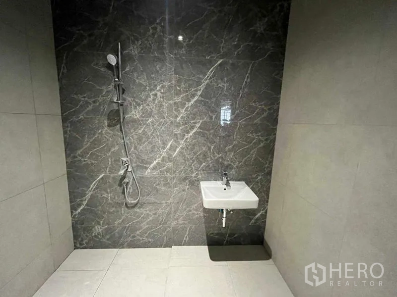 Office Space for rent in Phra Khanong, Bangkok - Shower room with wall-mounted sink and grey marble feature wall.