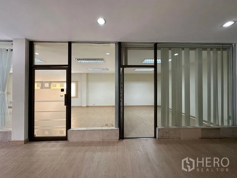 货栈 出租在Suan Luang, Bangkok - 玻璃店面与门框、百叶帘，通向明亮办公区。