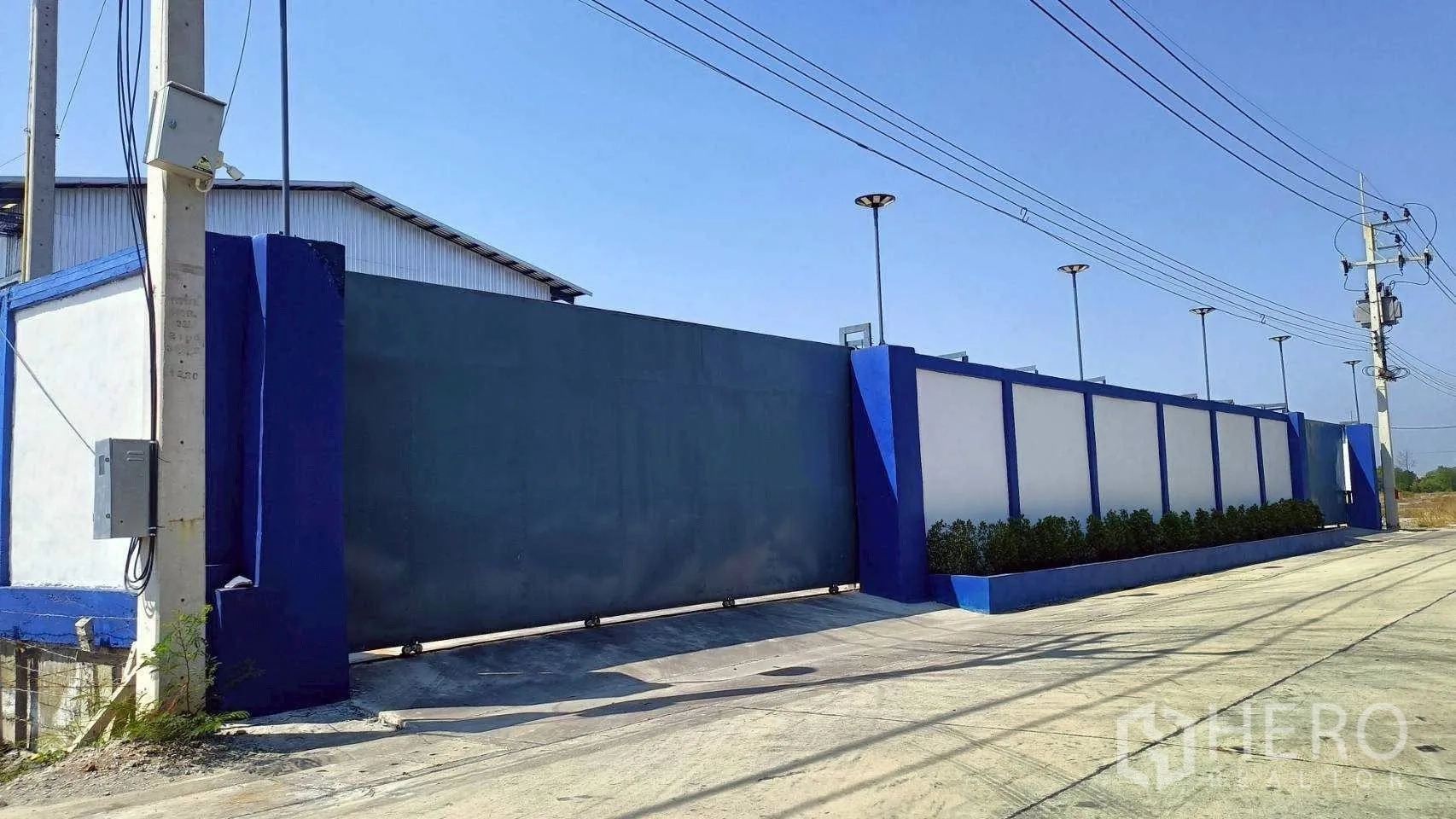 工厂 for rent or sale in Mueang Samut Sakhon, Samut Sakhon - 入口转角处的安防大门与绿化围墙。