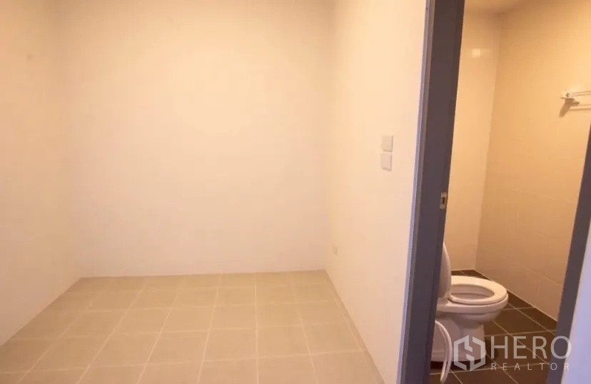 Detached House for rent in Bang Phli, Samut Prakan - Narrow side yard with grass strip, windows and outdoor AC unit.