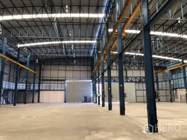 Factory for rent or sale in Bang Sao Thong, Samut Prakan - Deep warehouse bay with steel structure, skylights and a large roller door suitable for truck access.
