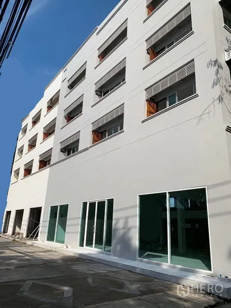 办公空间 出租在Huai Khwang, Bangkok - 白色多层办公楼外观，一层大面积玻璃门与前方铺装空地。