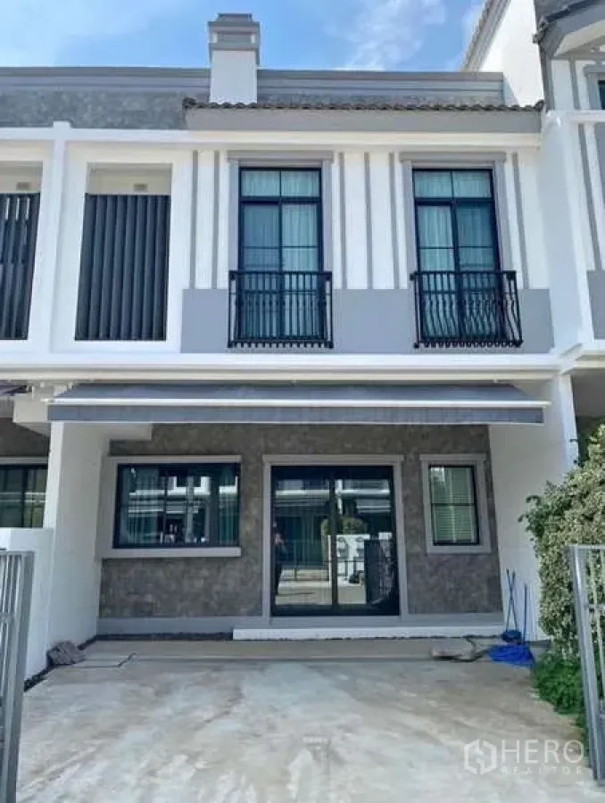 Townhouse for rent in Bang Phli, Samut Prakan - Modern two-storey townhouse exterior with balcony railings and front parking space.