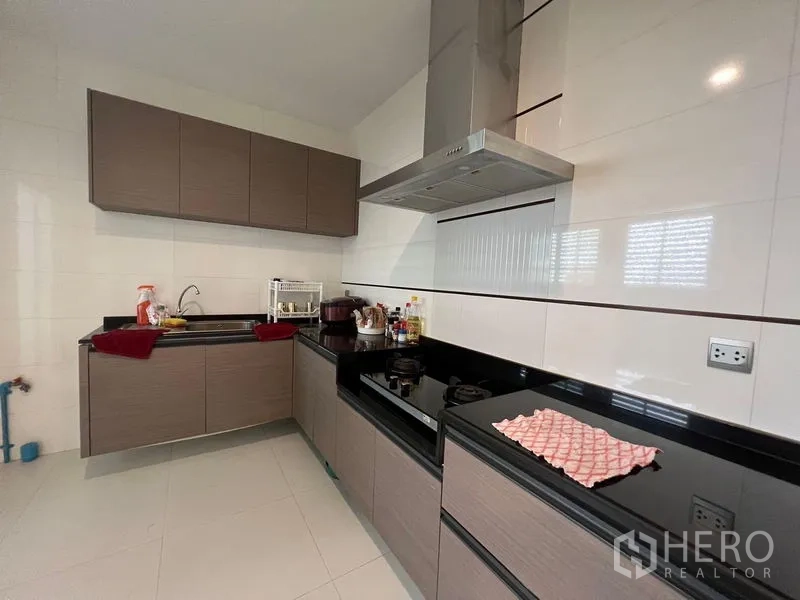 Detached House for sale - Separate Thai kitchen featuring L-shaped cabinetry, gas hob and stainless steel range hood.
