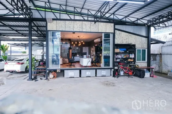 货栈 出租在Bueng Kum, Bangkok - 仓库立面，宽幅推拉玻璃门连接办公室，旁有收纳置物架。