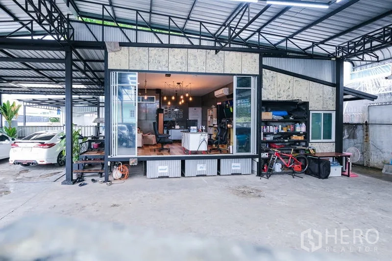 货栈 出租在Bueng Kum, Bangkok - 仓库立面，宽幅推拉玻璃门连接办公室，旁有收纳置物架。