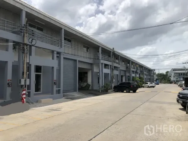 Factory for rent in Pak Kret, Nonthaburi - Wide internal road with parking bays in an industrial estate outside the factory units.