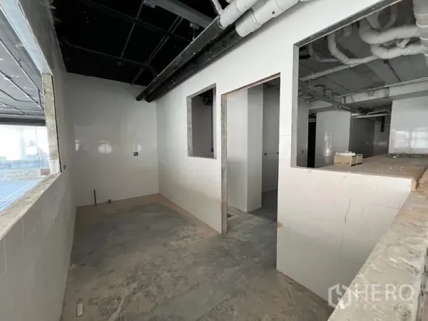 Retail Space for rent in Watthana, Bangkok - Back-of-house tiled rooms with service openings and piping ready for kitchen installation.