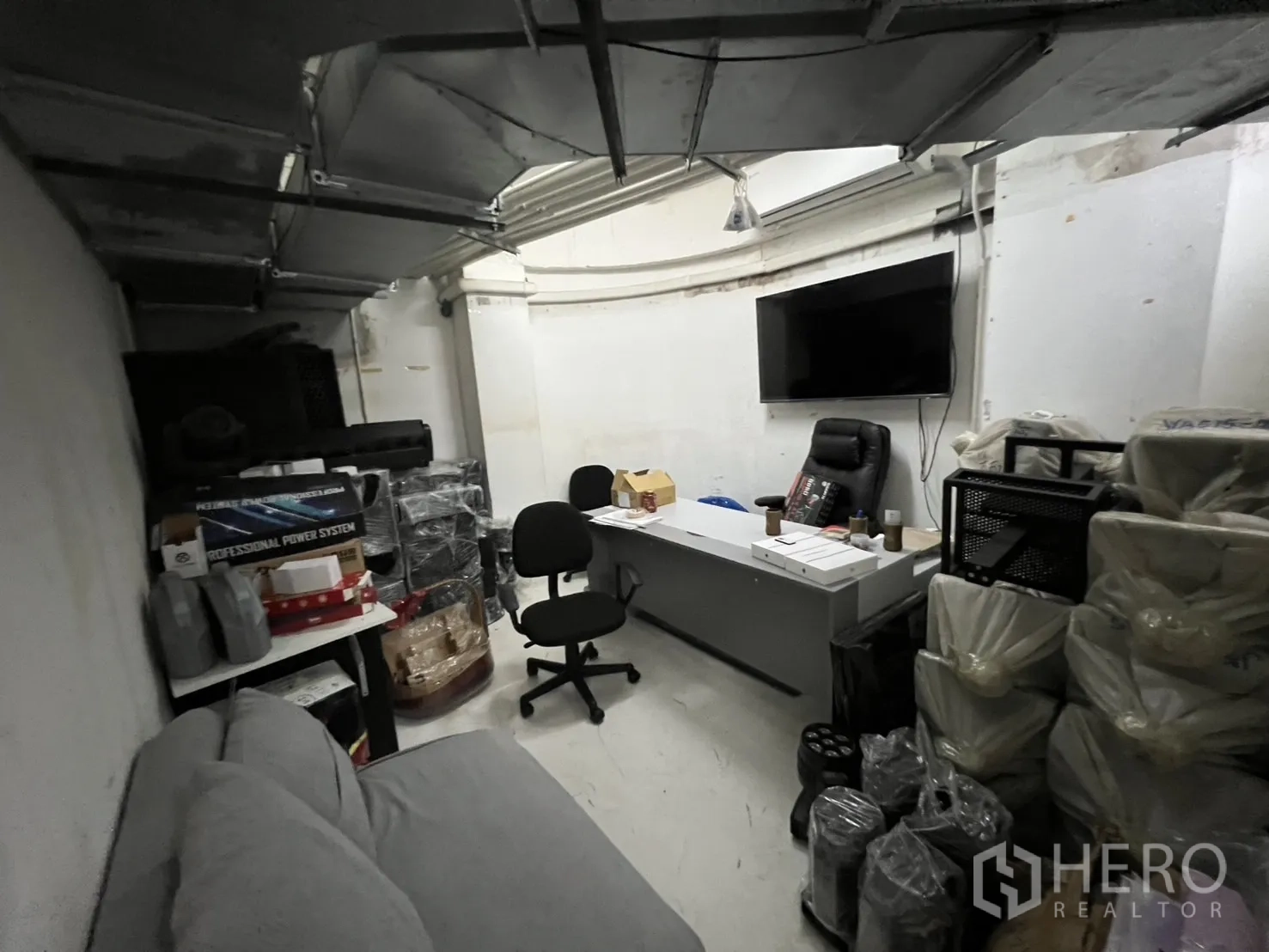 Retail Space for rent in Watthana, Bangkok - Back-office room with desk, sofa and wall-mounted TV.