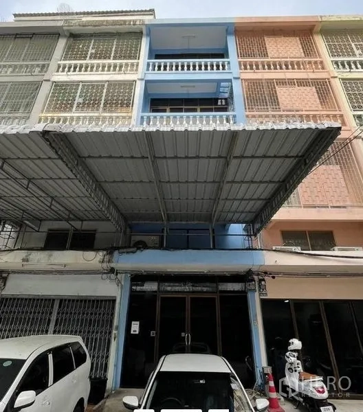 店屋 出租在Khlong Toei, Bangkok - 四层蓝色店屋外立面，带金属雨棚与门前停车位，位于Khlong Toei。