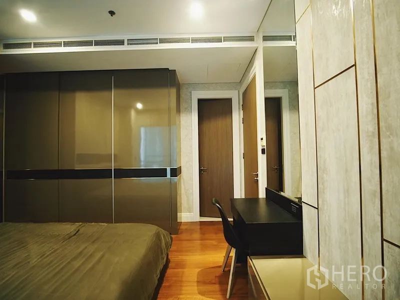 Condominium for rent in Khlong Toei, Bangkok - Second bedroom with built‑in wardrobes, work desk and wooden flooring.