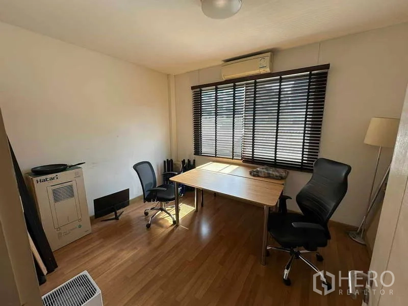 Home Office for rent in Chatuchak, Bangkok - Cozy office or bedroom with window blinds, desk, and chairs on wood floors.