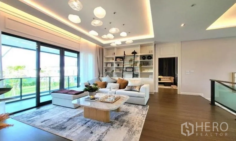 Detached House for sale in Bang Phli, Samut Prakan - Upstairs family lounge with built‑in shelving, wood floors, balcony sliders and cove lighting