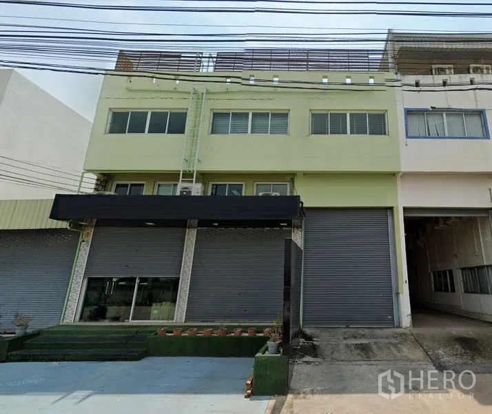 Warehouse for rent in Samut Prakan - Three-storey warehouse facade with roller shutters and a loading bay in Bang Phli.