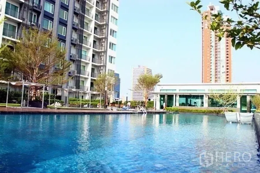Condominium for rent in Khlong Toei, Bangkok - Large outdoor swimming pool at a modern Khlong Toei condominium with landscaped gardens and city views.