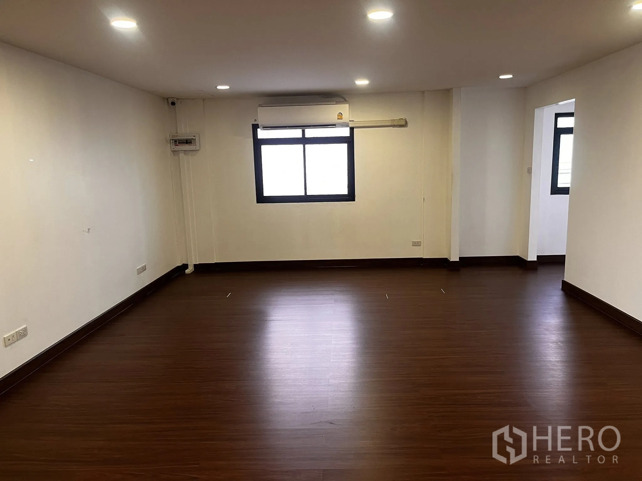 Warehouse for rent in Lat Phrao, Bangkok - Upstairs office room with window, recessed lighting, and a wall-mounted air conditioner.