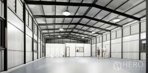 Warehouse for rent in Lat Phrao, Bangkok - Bright warehouse hall showing partitioned office rooms and restrooms with smooth flooring and suspended lights.