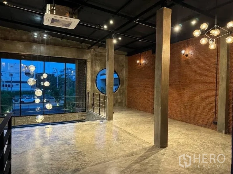 Standalone for rent in Sathon, Bangkok - Double-height space with hanging globe pendant lights, large picture window, round window and metal staircase railing.
