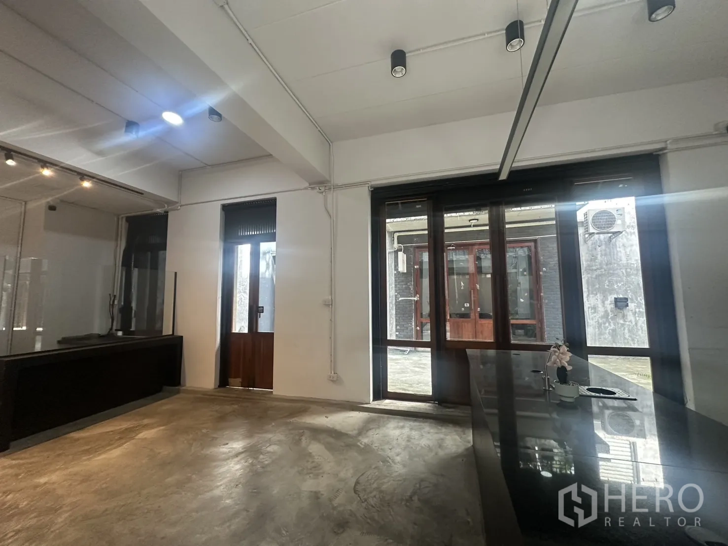 Home Office for rent in Pathum Wan, Bangkok - Spacious ground level with track lighting, glass entry and smooth concrete flooring.
