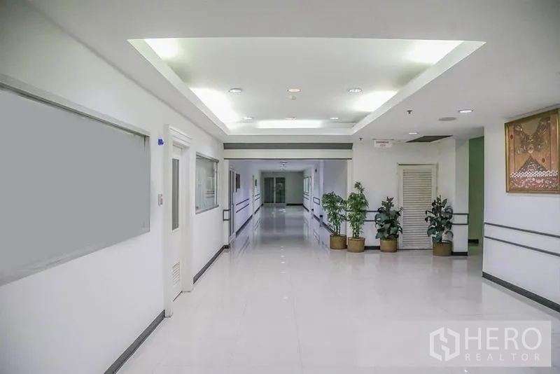 Office Space for rent in Bang Na, Bangkok - Wide interior corridor with recessed lights, polished floors, and decorative plants.