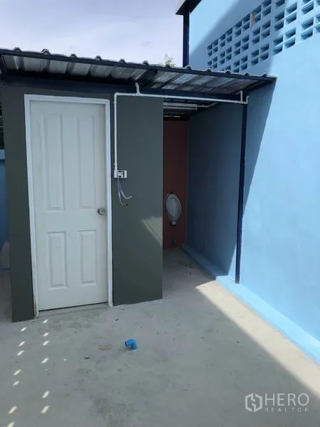 Factory for rent or sale in Bang Bua Thong, Nonthaburi - Outdoor washroom with covered urinal area beside the building.