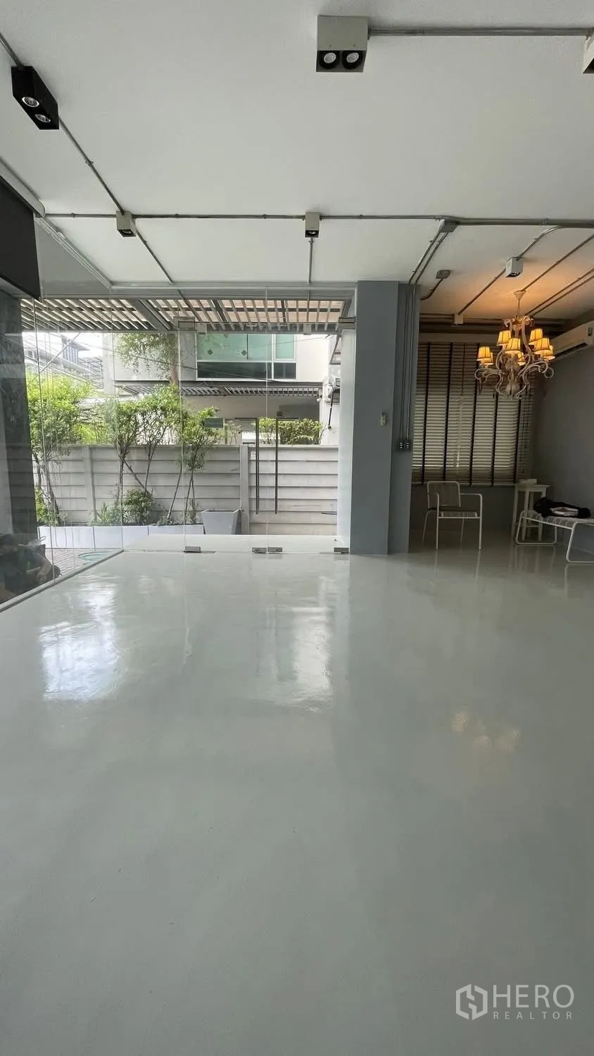 Home Office for rent or sale in Wang Thonglang, Bangkok - Ground-floor open space with glossy floor, glass doors, and small garden view.