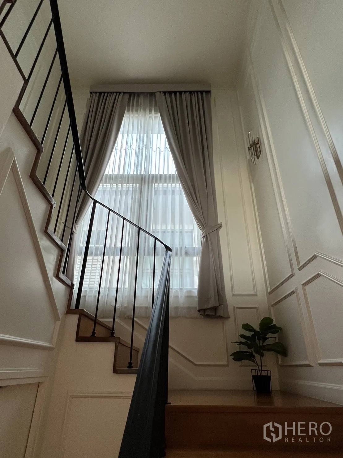 独立式住宅 出租在Suan Luang, Bangkok - 楼梯间，金属扶手与高窗纱帘。