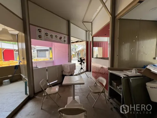Retail Space for rent in Khlong Toei, Bangkok - Central retail zone with tables and chairs beside serving window and fan, connecting to outdoor seating.