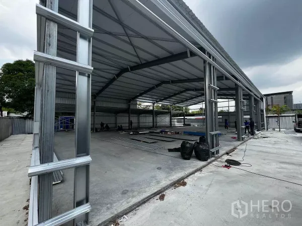 Warehouse for rent in Lak Si, Bangkok - Side view of the metal warehouse structure showing tall ceilings and a spacious loading apron.