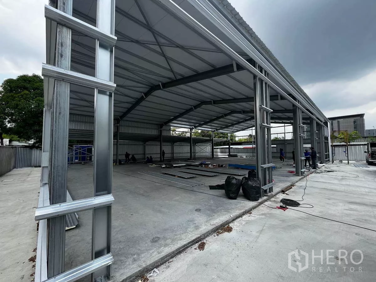 Warehouse for rent in Lak Si, Bangkok - Side view of the metal warehouse structure showing tall ceilings and a spacious loading apron.