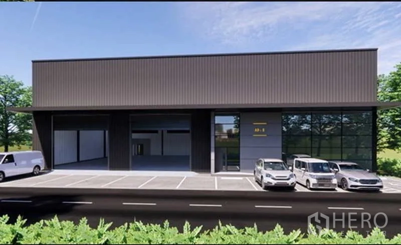 Warehouse for rent in Pak Kret, Nonthaburi - Modern dark-clad warehouse exterior in Pak Kret with three roller-shutter loading bays, wide driveway and ample parking.