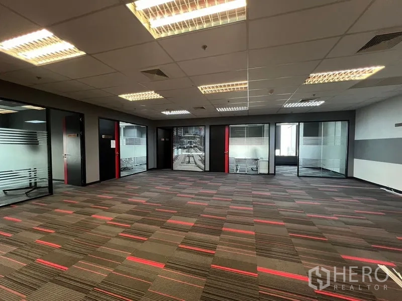 Office Space for rent in Huai Khwang, Bangkok - Open office with ceiling lights and multiple glass offices around the perimeter.